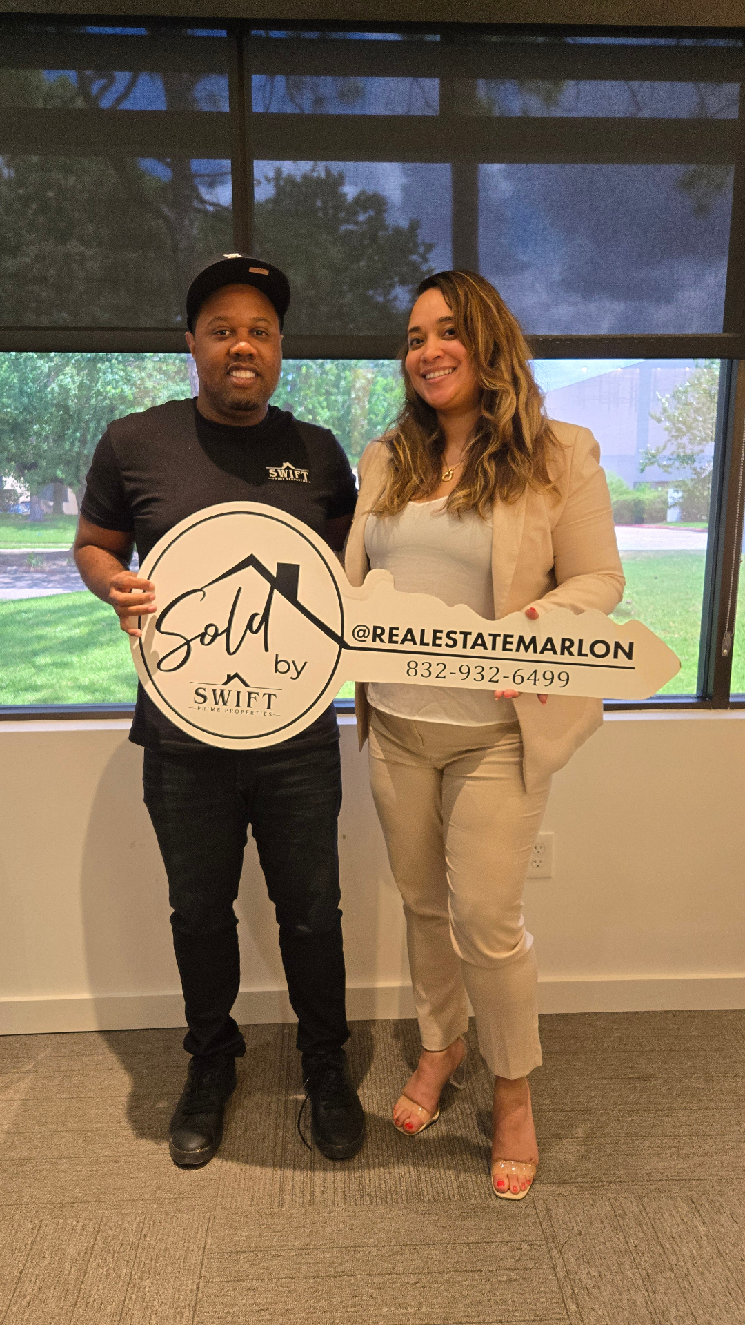 Marlon Wilson standing with a client and a sold key sign at closing.